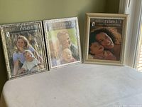 Three new decorative picture frames with silver textured borders displayed upright.