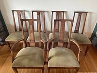 Six walnut dining chairs arranged in two rows, front row two armchairs and back row four side chairs