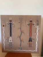 Full frontal image of the square Navajo sand painting showing two figures and central plant motif.