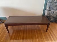Full view of the rectangular walnut coffee table showing top, legs, and overall profile.