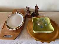 Full lot on table showing Scottie dog bookends, daisy platter, Shawnee planter, surfboard tray, sun shape tray, and glass pitcher