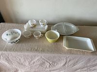 Full lot of vintage glass and milk glass kitchenware on beige cloth