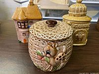 Photo of all three vintage ceramic cookie jars together showing deer, house, and beehive designs