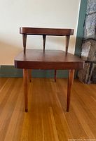 Front view of the vintage mid-century two tier wooden step table.