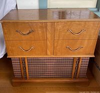 Front view of a vintage Viking stereo cabinet showing four wooden drawers with brass handles and original speaker grill with patterned cloth and decorative wooden accents.