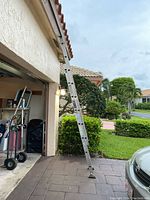 Full view of the aluminum extension ladder extended and leaning against a building.