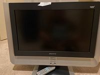 Front view of the Advent 22 inch flat screen TV with remote control placed below it, showing the HDTV label and the Advent logo on the frame.