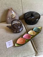 Photo showing all four items grouped together: Mikasa Opus Black black covered dish, brown teapot with Asian characters, leaf sushi tray with four leaf-shaped dishes, and brown glazed flower vase.