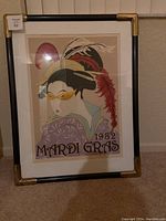 Full view of the framed Mardi Gras print featuring a stylized figure with feathers and glasses, with the text '1982 MARDI GRAS'