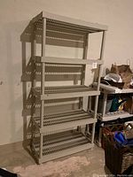 Five-level off-white plastic shelving unit placed against a wall, showing slatted shelves and sturdy frame.