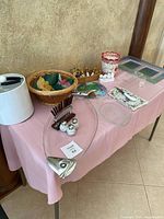 Photo of assorted Sunday brunch serving items on table with pink tablecloth including large fish platter, bagel basket and various cheese boards