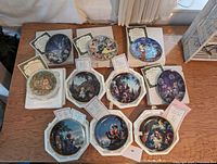 Photo showing all 10 collector plates on a table with certificates of authenticity visible