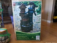 Photo of packaging front showing birdhouse fountain image and product name.