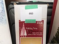 Box front showing Holiday Time 32 inch fiber optic Christmas tree label and price of $19.96