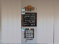 Full view of all spoon displays mounted on the wall including wooden racks and display case.