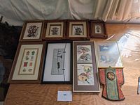 Overview photo of lot with nine framed art pieces and one decorative item arranged on floor