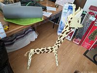 Photo of the wooden giraffe-shaped kids hanging rack from left side angle showing full height and structure.