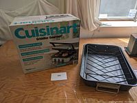 Photo showing the Cuisinart Griddler Gourmet box and the roasting pan with rack placed on table.