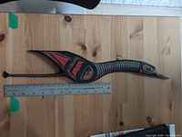 Full view of heron carving on tabletop with ruler for scale