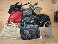 Overview of all 8 purses and handbags arranged on floor showing variety of styles and colors