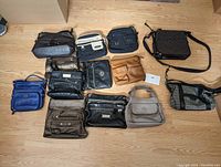 Full view of the 11 assorted purses and handbags arranged on the floor showing their shapes and sizes.