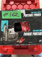 Front and top of box showing product branding, 750 peak amps, and clamp images.