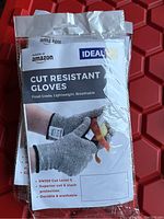 Packaged Ideal cut resistant gloves with label showing front cover describing the product and usage
