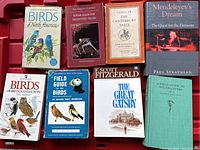 Photo of 8 books including bird guides, literature, and science books.