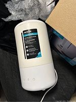 Image of NOMA humidifier showing ion exchange filter label and control buttons on the front, white cylindrical design.