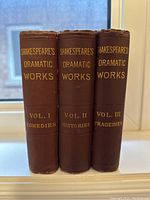 Photograph of the spines of three hardcover books showing titles Shakespeare's Dramatic Works Vol I, II, and III in gilt on brown bindings.