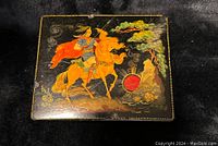 Photo of the small hand-painted wooden box with detailed horseman artwork, showing front design.