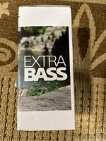 Side of box showing EXTRA BASS logo on white background with a nature stone background image.