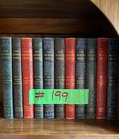 Books arranged on a wooden shelf, showing spines and titles