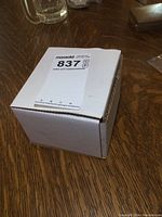 Closed white cardboard box marked with a lot sticker, containing basketball cards inside.