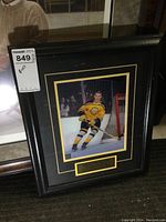 Framed Bobby Orr photo in black frame with plaque below, showing the full lot.