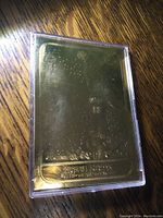 Gold foiled Fleer Premier Michael Jordan basketball card stored in a hard plastic case on a wooden surface.