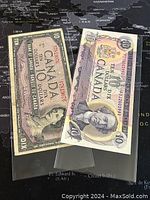 Two Canadian 10 dollar paper banknotes, one from 1954 and one from 1971, displayed side by side in plastic protection sleeves.