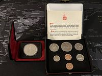 Overall view of the open case showing the 8 coin specimen set including the commemorative silver dollar and other coins.