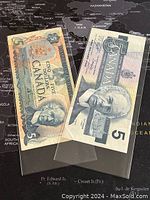 Two Canadian 5 dollar banknotes displayed with front sides visible. One banknote dated 1979 and the other 1986.