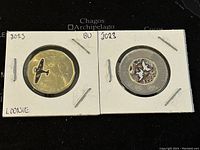 Front side of the two 2023 Canadian colored circulation coins in holders showing airplane design on Loonie and bird design on Twoonie.