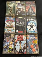 Nine PlayStation Portable (PSP) games laid out on a flat surface, showing cover artwork and titles.