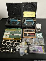 Lot overview showing all items flatly displayed including tools, cutting system, screws, and hooks