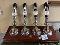 Front view of all four beer taps mounted on wooden board
