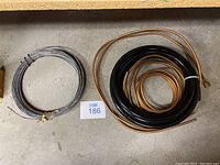 Coiled copper pipes, black PVC tubing, and metal wire coil