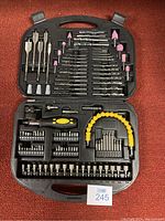 Full view of the drill bit carrying case open showing organized drill bits, grinding stones, screwdriver bits, flexible extension, and ratcheting screwdriver handle.