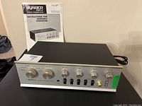 Front view of Dynaco PAT-4 preamplifier with manual standing behind