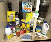 Kitchen cleaners and garbage bags arranged under sink showing all items in lot.