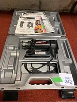 Rotozip spiral saw in molded carrying case along with manuals and pamphlets.