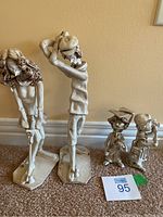 Photo showing all four signed Dino Bencini sculptures arranged on the floor: two taller female figures and two smaller child-like figures.