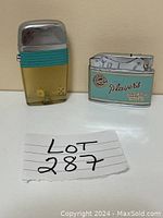 Photo of both vintage lighters side by side with lot number visible